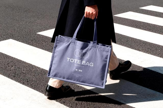 Tote Bag Mockup Held in Motion on Crosswalk